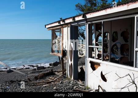 Maison détruite par l'érosion côtière et l'élévation du niveau de la mer, plage Haumoana, baie Hawkes, Île du Nord, Nouvelle-Zélande Banque D'Images