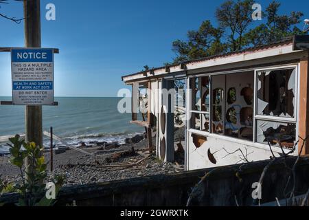 Panneau de danger en face de la maison détruit par l'érosion côtière et l'élévation du niveau de la mer, Haumoana Beach, Hawkes Bay, Île du Nord, Nouvelle-Zélande Banque D'Images