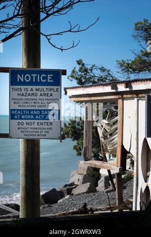 Panneau de danger en face de la maison détruit par l'érosion côtière et l'élévation du niveau de la mer, Haumoana Beach, Hawkes Bay, Île du Nord, Nouvelle-Zélande Banque D'Images