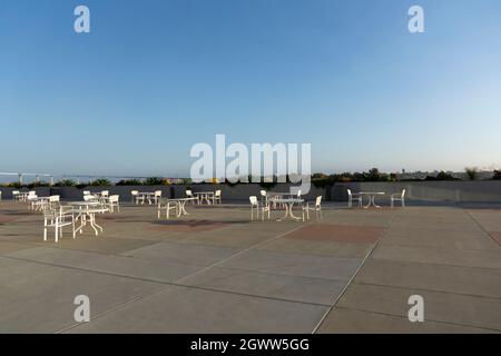 Ensemble de chaises et de tables extérieures en plastique blanc sur un toit. Coin salon Banque D'Images