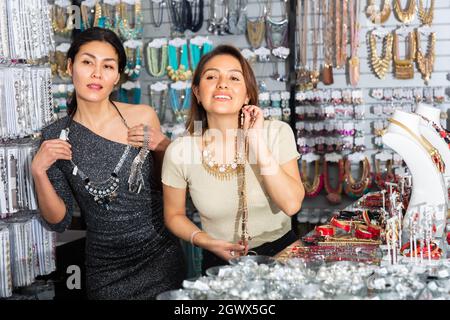 Des femmes heureuses qui choisissent des décorations stylées dans la boutique de vêtements de sport Banque D'Images