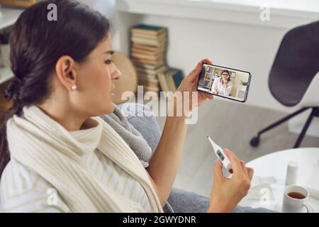 Femme ayant une consultation médicale avec un médecin en ligne par appel vidéo sur téléphone portable Banque D'Images