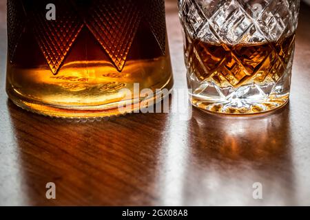 La carafe de cognac et un verre sont sur la table de cuisine libre. Banque D'Images