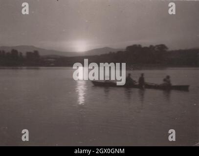 photo monochrome vintage originale sur une famille dont l'aviron se retrouve sur la rivière jusqu'au coucher du soleil.C'est un temps absolument super de qualité pour chaque famille.Période: Années 1930 ou début des années 1940- Source: Photographie originale Banque D'Images