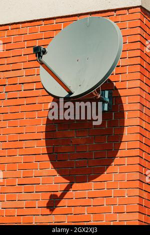 Ancien satellite plat monté sur mur de briques maison, foyer sélectif Banque D'Images