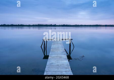 Eau calme le matin sur le Danube et la jetée avant l'heure bleue du lever du soleil Banque D'Images