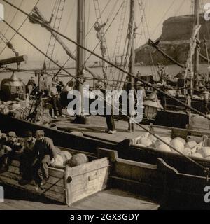 Pêcheurs en sabots à bord de chalutiers néerlandais dans le port de Whitby, Yorkshire, Angleterre, en 1953. Photographie vintage d'une collection privée. Banque D'Images