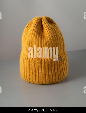 Petit chapeau tricoté jaune sur fond gris. Chapeau en laine gros plan. Copier l'espace Banque D'Images