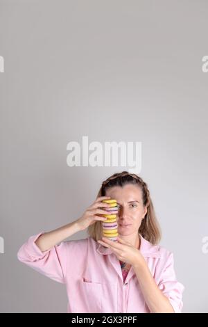 Portrait de femme authentique avec macarons entre les mains. Photo de style de vie de confiseur. Banque D'Images