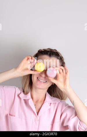 Portrait de femme authentique avec macarons entre les mains. Photo de style de vie de confiseur. Banque D'Images