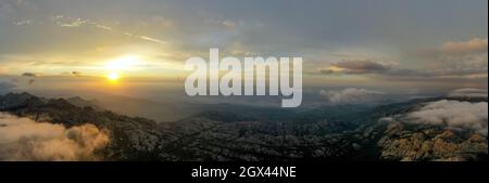 Vue d'en haut, prise de vue aérienne, vue panoramique stupéfiante d'une chaîne de montagnes pendant un lever de soleil spectaculaire. Mont Limbara (Monte Limbara) Sardaigne, Italie. Banque D'Images