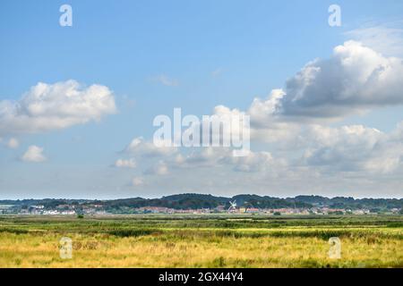 Vue sur CLEY à côté du village de la mer de la route à Blakeney Freshes avec grand ciel bleu et des nuages blancs moelleux, Norfolk, Angleterre. Banque D'Images