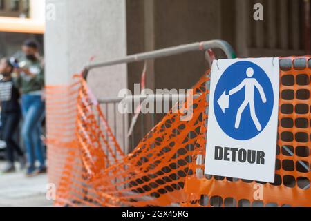 Le panneau indique un détour gauche pour les piétons Banque D'Images