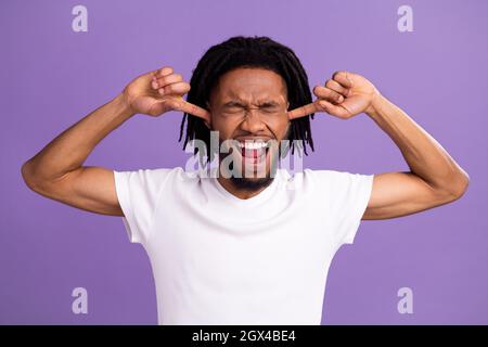 Portrait d'un type attrayant désespéré fermer les oreilles criant isolé sur fond violet vif de couleur violet lilas violet Banque D'Images