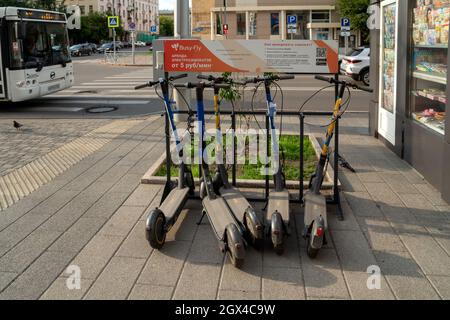 Stationnement de scooters électriques sur la rue Karl Marx, avec des règles de location par l'application en russe. Banque D'Images