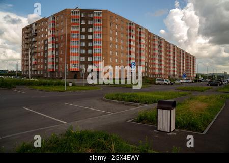 Immeuble résidentiel d'appartements et voitures garées dans un parking à proximité dans le nouveau microquartier Yasny. Banque D'Images
