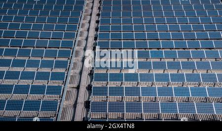 Panneaux solaires ou collecteurs sur le toit d'un bâtiment industriel. Vue verticale au-dessus de drone des panneaux solaires installés sur un toit. Banque D'Images