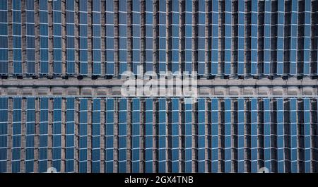 Panneaux solaires ou collecteurs sur le toit d'un bâtiment industriel. Vue verticale au-dessus de drone des panneaux solaires installés sur un toit. Banque D'Images