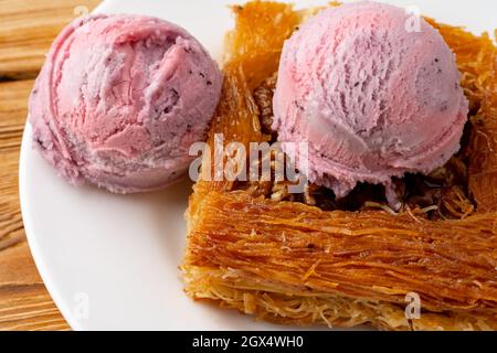 Dessert turc kunefe servi avec de la crème glacée sur fond de bois Banque D'Images