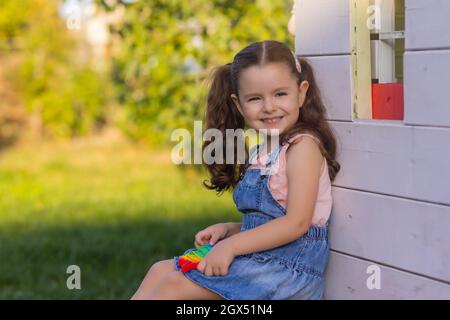 Enfant jouant avec pop il, appuyant sur les bulles avec ses doigts, vue de dessus.Nouveau jouet antistress pour les enfants et les adultes.espace de copie pour le texte ou le design Banque D'Images