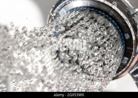 L'eau coule de la pomme de douche, vue rapprochée. Banque D'Images