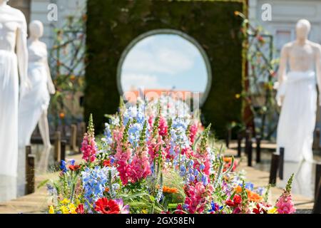 Gros plan dans une belle vue d'une décoration de fleurs colorées et de trois statues blanches Banque D'Images
