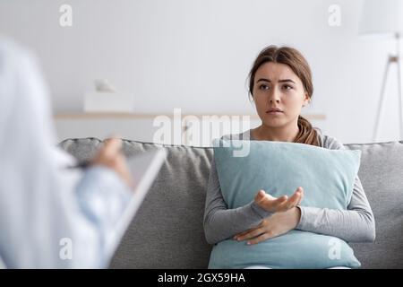 Une femme européenne triste et malheureuse souffrant de dépression et de santé mentale, parlant à l'aide d'un psychologue Banque D'Images