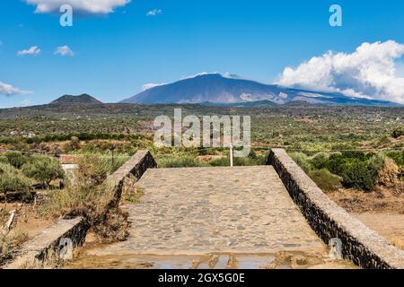 Le volcan Etna vu du 11c Ponte dei Saraceni (Pont des Saraceni) au-dessus de la rivière Simeto, près d'Adrano, Sicile, Italie Banque D'Images