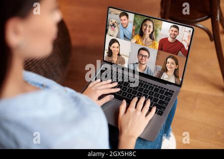 Une jeune femme européenne sérieuse communique avec des amis sur l'écran d'un ordinateur portable Banque D'Images