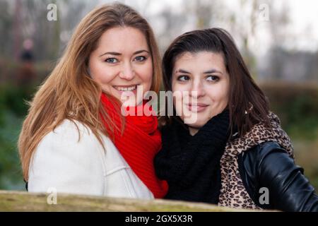 VAALS, POLOGNE - 04 novembre 2010 : une femme portant un foulard rouge et une amie avec une veste en cuir dans un parc. Banque D'Images