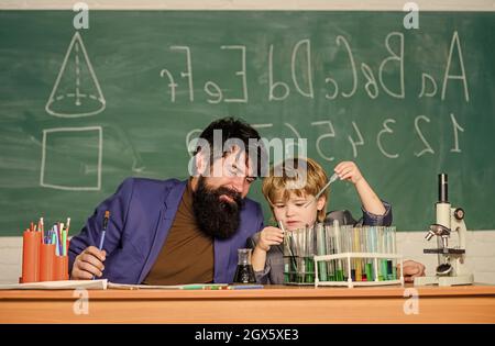 Connaissances de base en chimie. Étudier la chimie et la biologie. Jouez avec des liquides. Exemple personnel inspirant. Connaissances scolaires. Enseignant et garçon Banque D'Images