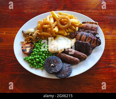 Assiette traditionnelle anglaise de viandes grillées mélangées, frites, œufs et pudding noir Banque D'Images