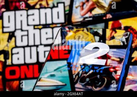 Logo Take-Two sur l'écran du smartphone. Un cadre du jeu GTA en arrière-plan. Banque D'Images