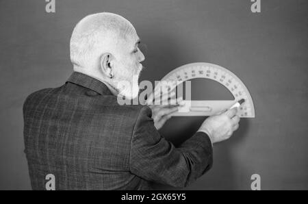 pas d'erreurs. Éducation et concept d'école. Apprentissage à domicile. Professeur d'homme senior utilisant l'outil de rapporteur. Tuteur barbu dessiner avec la règle sur le tableau noir Banque D'Images
