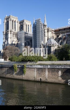 Paris, France, le 4 octobre 2021 : la cathédrale notre-Dame sur l'île de la Cité dans le centre de Paris, lors d'une journée d'automne ensoleillée avec un ciel bleu pur. La cathédrale est en cours de reconstruction après qu'elle ait été partiellement détruite par un incendie en 2019. Il a fallu jusqu'en novembre 2020 pour que le bâtiment soit sécurisé et les travaux de restauration ont maintenant commencé. Le site est clôturé et des échafaudages et une grue d'environ 80 m de haut domine le site à côté de la Seine. Anna Watson/Alay Live News Banque D'Images