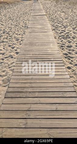planches, passerelle en bois traversant le sable sur la plage. bois clair massif. fond texturé Banque D'Images