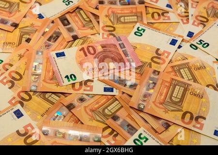 Les billets en coupures de 50 et 10 euros sont dispersés au hasard sur le fond, la texture de la monnaie européenne. Nouveau Banque D'Images