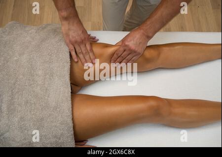 Femme recevant un massage de drainage lymphatique des jambes dans le salon de spa. Gros plan. Relaxation du corps beauté et soins du corps concept. Banque D'Images