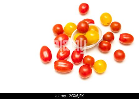 Petites tomates rouges et jaunes isolées sur fond blanc Banque D'Images