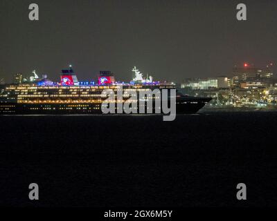 Sheerness, Kent, Royaume-Uni. 4 octobre 2021. Le bateau de croisière 'Disney Magic' a quitté la Tamise pour la dernière fois cette année, en passant par les lumières vives de Southend en arrière-plan, comme vu de Sheerness dans le Kent. Disney Magic a effectué un certain nombre de courtes croisières de marche depuis Tilbury, mais ce soir a été le dernier départ pour cette année. Crédit : James Bell/Alay Live News Banque D'Images