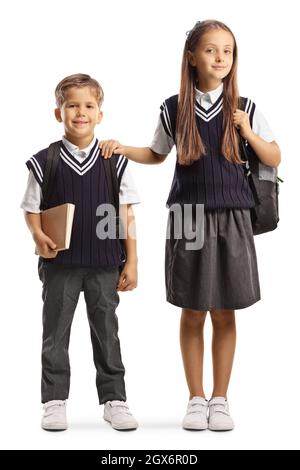 Frère et sœur aînée en uniforme scolaire isolée sur fond blanc Banque D'Images