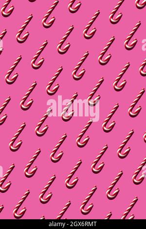 Motif de canne de Noël sans couture sur fond rose pour les fêtes Banque D'Images