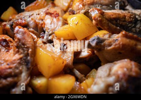 Les ailes de poulet frites avec pommes de terre sont cuites dans une casserole, en gros plan avec une faible profondeur de champ Banque D'Images