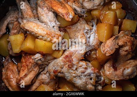 Les ailes de poulet frites avec pommes de terre sont cuites dans une casserole, en gros plan avec une faible profondeur de champ Banque D'Images