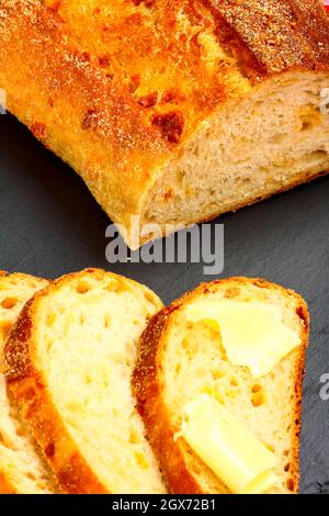 Tranches de pain au levain sur un plat de service en ardoise Banque D'Images