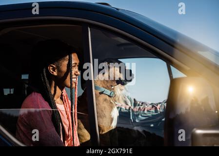 Jeunes filles multiraciales et chien s'amuser sur la route à l'intérieur de la camionnette de camping - Focus sur le visage de la femme africaine Banque D'Images