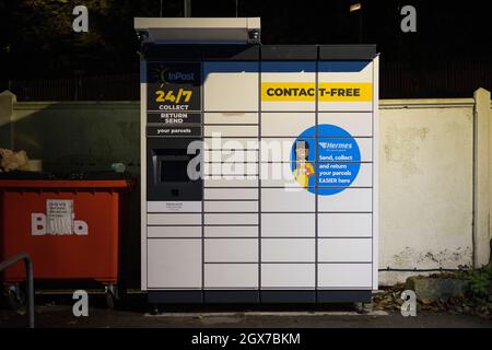 Casier de collecte de colis InPost vu la nuit dans le parking de la gare de Kenley, au sud de Londres. Banque D'Images