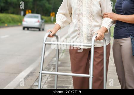 femme âgée utilisant une rue de passage de marcheur Banque D'Images