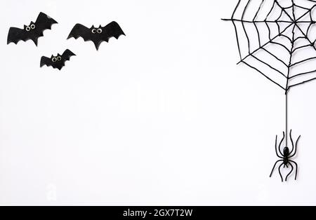 Thème Halloween avec araignées noires, toile et chauves-souris. Objets d'Halloween crépeux sur fond blanc avec espace pour le texte, plat. Le style minimaliste de Hallowen Banque D'Images