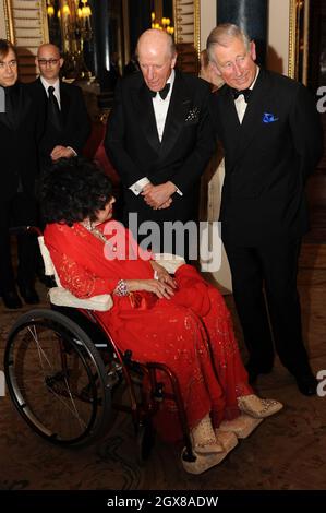 Prince Charles, Prince de Galles, Lord Rowe-Beddoe, président du Royal Welsh College (R) et actrice Dame Elizabeth Taylor, assis en fauteuil roulant, bavardent ensemble lors d'une soirée de gala au Royal Welsh College à Buckingham Palace à Londres, le 29 avril 2010. Banque D'Images